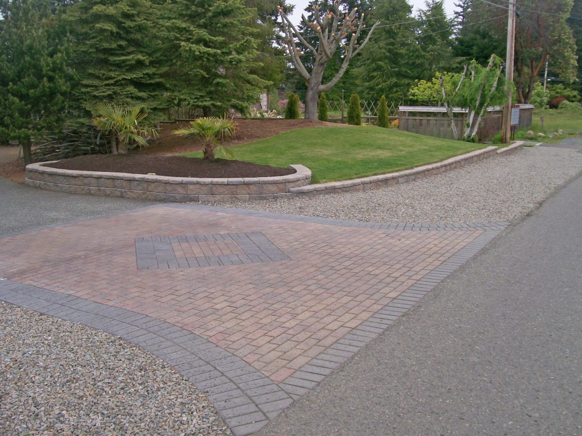 brick driveway with planters and lawn